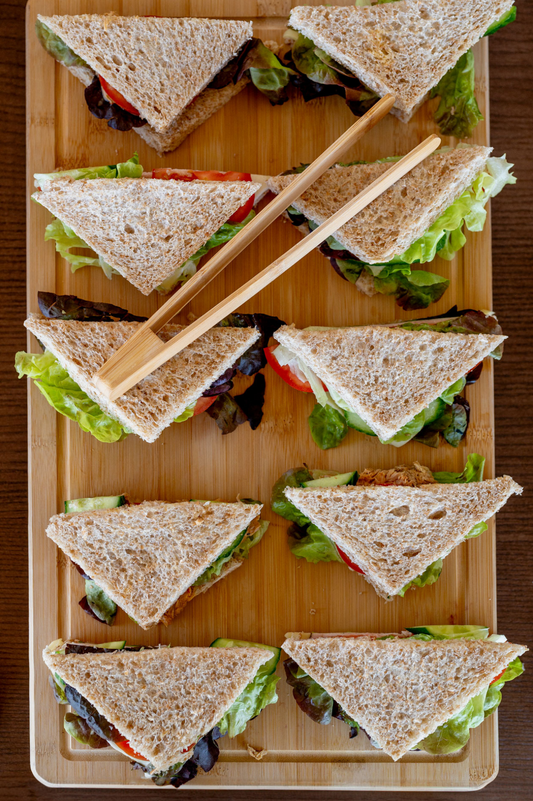 Mini Sandwiches with Salad, Tomato and Mozarella, placed on a wooden board.
